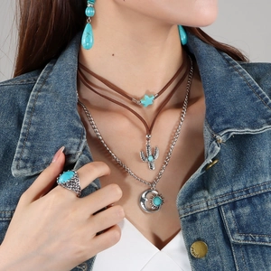 Detalle de conjunto de joyas bohemias con turquesa, collar y colgantes cactus