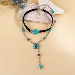 Λεπτομέρεια μποέμ βελούδινου choker με τυρκουάζ καρδιά και μενταγιόν πεταλούδα