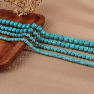 Macro detail of turquoise beaded necklaces set with round and flat heishi stone beads