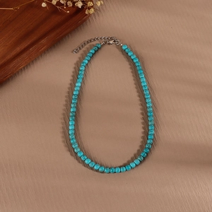 Detail of turquoise beaded necklace with natural stone texture and silver lobster clasp