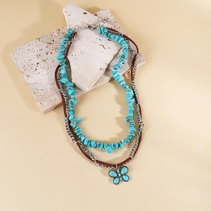 Détail du collier bohème avec pierres turquoise, cordon en cuir et pendentif papillon