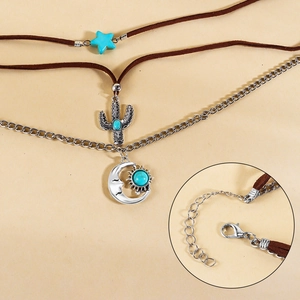 Detalle del collar bohemio de varias capas con colgantes de luna, sol y cactus turquesa
