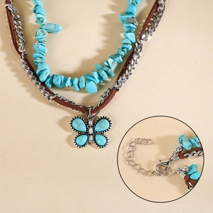 Détail du pendentif papillon turquoise bohème avec chaînes multicouches en cuir et pierre