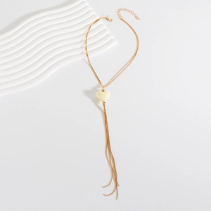 Dettaglio della collana a catena a serpente dorata con ciondolo a cuore crema e chiusura