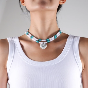 Close-up of double-layered turquoise bead necklace with a marble-textured heart pendant