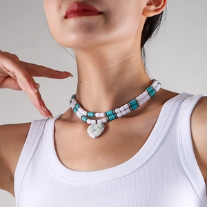 Detail of double-layer beaded necklace with turquoise spacers and marble heart pendant