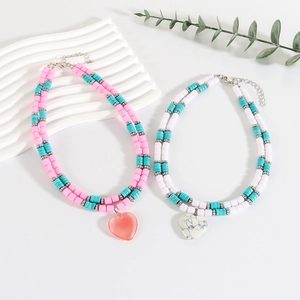 Double-layer beaded necklace with turquoise stones and heart pendant on white background