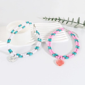 Detail of bohemian double-layered beaded necklaces with heart pendants and turquoise accents