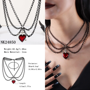 Dettaglio collana gotica a più strati in ferro nero con cuore rosso e croce