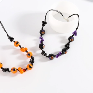 Détail du collier d'Halloween avec imprimés citrouille et chauve-souris sur perles noires