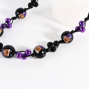 Vue détaillée du collier d'Halloween avec perles en bois et motifs citrouille