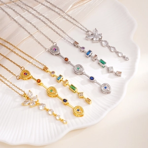 Elegante Halsketten mit Schmetterling-Anhänger und bunten Zirkoniasteinen auf Keramik