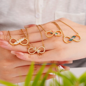 Golden infinity necklaces with colorful crystals held in hand for a close-up elegant view