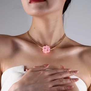 Makroaufnahme von rosa Perlenanhänger mit mehrsträngiger Golddrahtkette für Damen