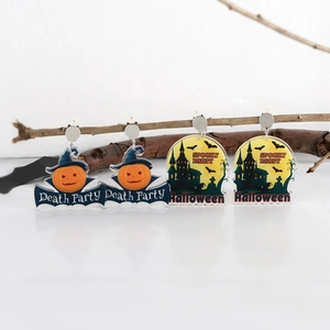 Dettaglio orecchini di Halloween in acrilico con motivi di zucca e castello spaventoso