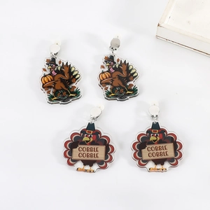 Close-up of Thanksgiving acrylic turkey clip-on earrings with Gobble Gobble text