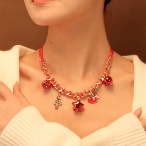 Dettaglio collana di Natale con nastro rosso catena dorata e ciondoli festivi