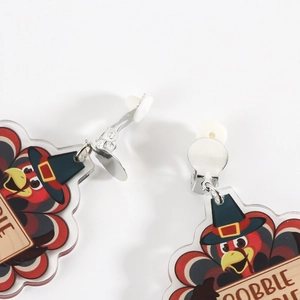 Macro detail of Thanksgiving turkey earrings showing U-shaped clips and silicone pads