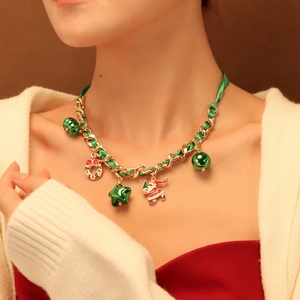 Dettaglio della collana di Natale con ciondoli Babbo Natale e nastro verde intrecciato