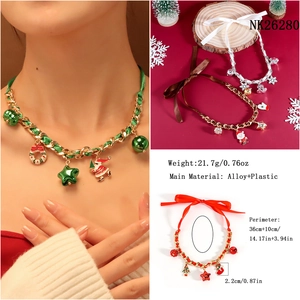 Detail view of festive Christmas necklace with Santa and tree charms on a gold chain