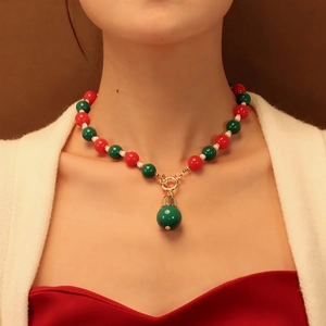 Détail du collier de perles festives rouges, vertes et blanches avec fermoir doré