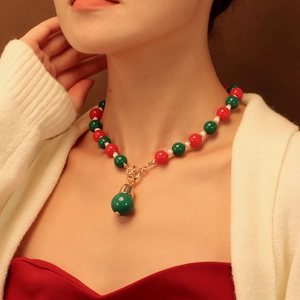 Gros plan du collier de perles rouge et vert festif avec fermoir OT doré sur modèle