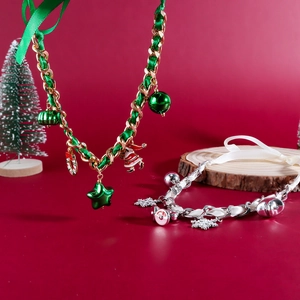 Dettaglio di collane natalizie intrecciate con ciondoli a forma di Babbo Natale e neve