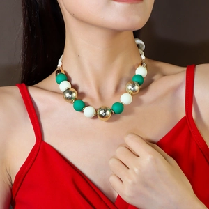 Chunky green, cream, and gold acrylic beaded necklace shown on a model neck