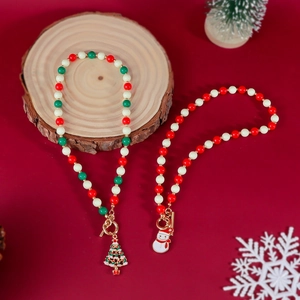 Festliche Perlenhalsketten mit Weihnachtsbaum- und Schneemann-Anhängern auf Holzdeko