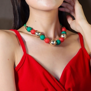 Detail of Christmas beaded necklace featuring red, green, and gold frosted beads on a model