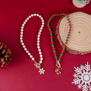 Detail von Weihnachtsperlenketten mit Schneeflocken- und Weihnachtsmann-Anhängern auf rotem Grund