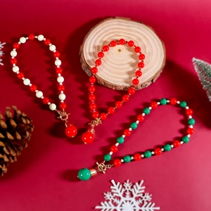Détail de colliers de perles de Noël avec fermoirs OT dorés et pendentifs sphériques