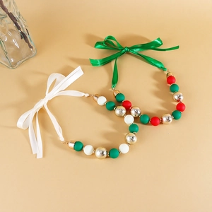 Detailed shot of Christmas acrylic beaded necklaces with ribbon bows in red and green