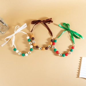 Close-up of three acrylic beaded necklaces with satin ribbons in festive Christmas colors