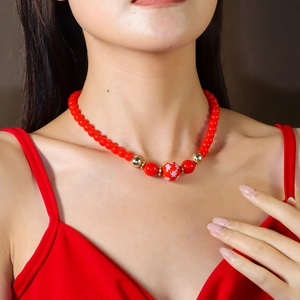 Gros plan d'un collier de perles rouges avec breloque flocon de neige sur un mannequin