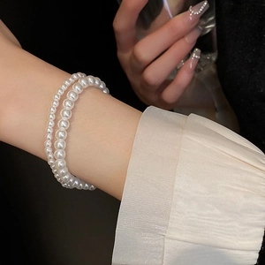 Close-up of elegant double-layer pearl bracelet with different sized white beads