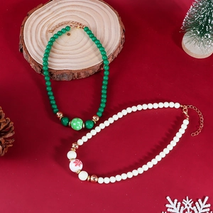 Détail de colliers de perles de Noël avec flocons et sapins sur fond rouge de fête