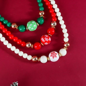 Gros plan d'un collier de perles de Noël avec motifs festifs de flocons et de sapins