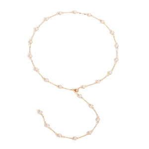 Dettaglio di un'elegante collana in lega dorata con perle bianche sparse su sfondo bianco