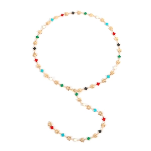 Dettaglio collana dorata con quadrifogli colorati e farfalle su sfondo bianco neutro