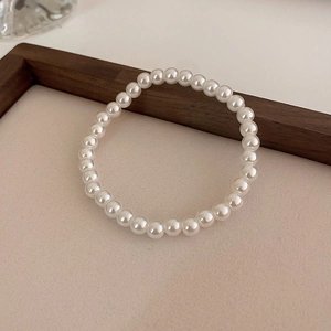 Detailopname van een elegante witte parelarmband van 6-8mm op een neutrale ondergrond