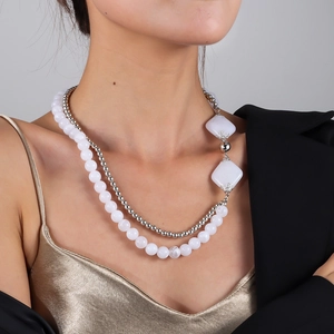 Nahaufnahme einer zweilagigen Halskette mit weißen Perlen und silbernen Details am Model