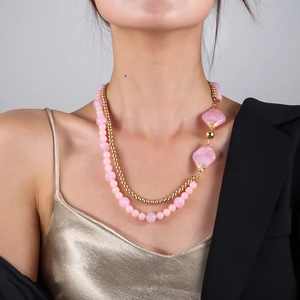 Detailansicht der eleganten zweilagigen Kette mit rosa Perlen und Goldkugeln am Modell