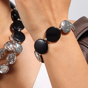 Details von klobigem Halsketten- und Armband-Set mit schwarzen und silbernen Scheiben