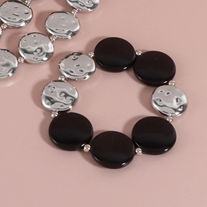 Details des elastischen Armbands mit schwarzen Perlen und silbernen Metallscheiben