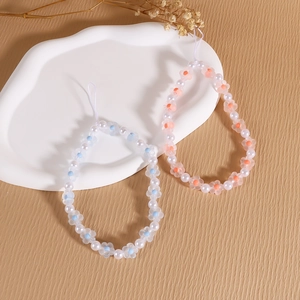 Detail of handmade beaded phone charms with translucent flower beads and pearls