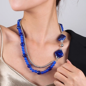 Detail einer zweilagigen blauen Perlenkette mit großen quadratischen Anhängern am Modell