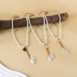 Ensemble de trois colliers en perles avec pendentifs papillon et glands sur branche