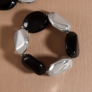 Detailansicht eines elastischen klobigen Armbands mit schwarzen und silbernen Perlen