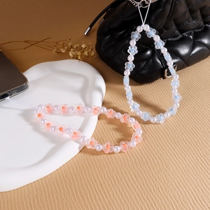 Detail of light pink and blue beaded phone straps with acrylic flowers and pearls